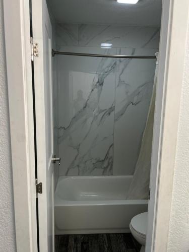 a bathroom with a marble shower stall with a toilet at crown inn in Memphis