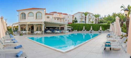 a pool at a resort with chairs and umbrellas at Princess Hotel in Lassi