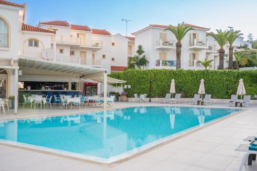 a swimming pool in a resort with chairs and umbrellas at Princess Hotel in Lassi