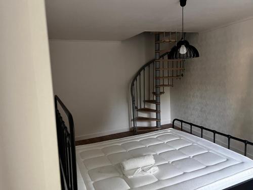 Ce lit se trouve dans un dortoir doté d'un escalier en colimaçon. dans l'établissement MAISON individuelle, à Saucats