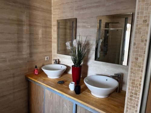 - une salle de bains avec deux lavabos sur un comptoir en bois dans l'établissement MAISON individuelle, à Saucats