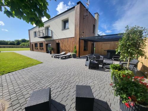 a patio with benches and tables in front of a building at Apartamenty Rzucewska 87 in Żelistrzewo