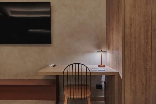 a room with a desk with a chair and a lamp at Kuuna Luxury Stays by Wynwood House in Medellín