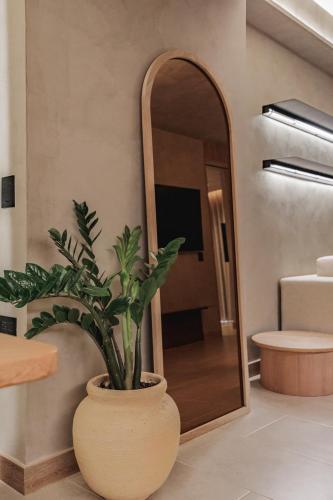 a plant in a vase in front of a mirror at Kuuna Luxury Stays by Wynwood House in Medellín