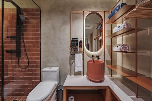 a bathroom with a toilet and a sink and a mirror at Kuuna Luxury Stays by Wynwood House in Medellín