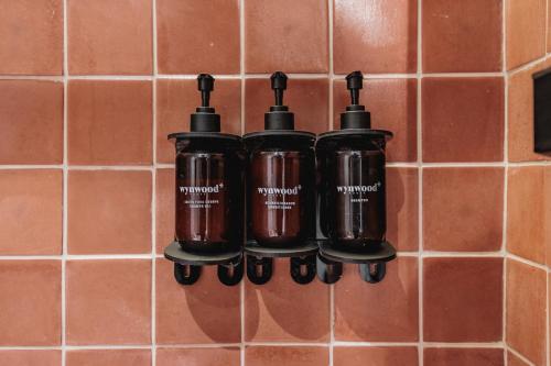 a group of bottles hanging on a tiled wall at Kuuna Luxury Stays by Wynwood House in Medellín