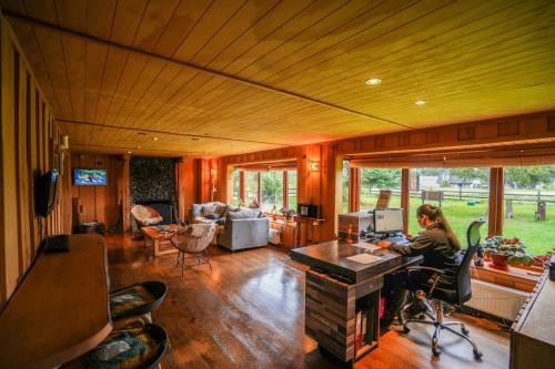 a woman sitting at a desk in a living room at Alto Melimoyu Hotel & Patagonia in La Junta