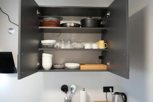 a black cabinet filled with dishes and utensils at InterPension in Garbsen