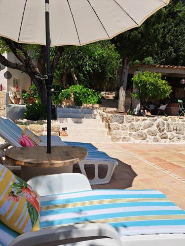 une table et des chaises avec un parasol sur une terrasse dans l'établissement Bastide de Marie Grasse, à Grasse