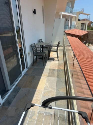 a balcony with a table and chairs on a building at Kalami Rooms Dhermi in Dhërmi