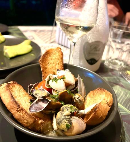 a bowl of food with bread and a glass of wine at Villa KAMBUSA appartamento SOFIA in Las Galeras