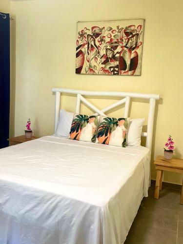 a bed with white sheets and pillows on it at Villa KAMBUSA appartamento SOFIA in Las Galeras
