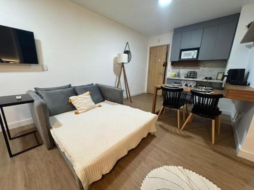 a living room with a bed and a kitchen at Century Plaza Vista Mar in Vitória