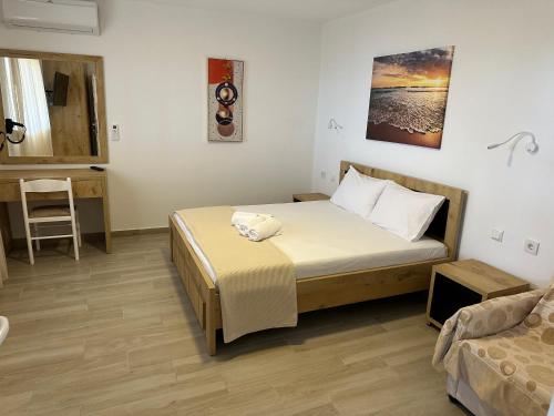 a small bedroom with a bed and a chair at Kalami Rooms Dhermi in Dhërmi