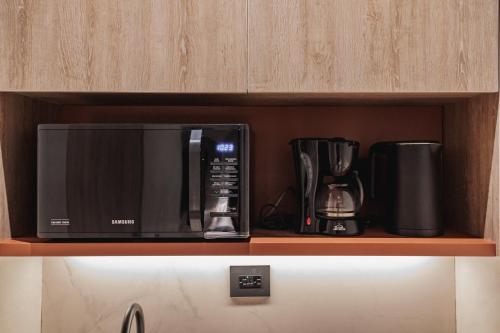 a black microwave sitting on top of a shelf at Kuuna Luxury Stays by Wynwood House in Medellín