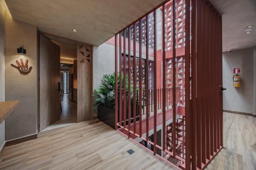 a hallway with a red metal staircase in a building at Kuuna Luxury Stays by Wynwood House in Medellín