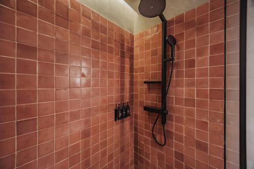 a shower in a bathroom with orange tiles at Kuuna Luxury Stays by Wynwood House in Medellín