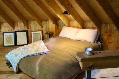 a bedroom with a bed in a wooden cabin at Escape to Tree House Island Life in Monmouth