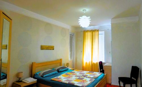 a small bedroom with a bed and a window at Pospolita Guest House in Kutaisi