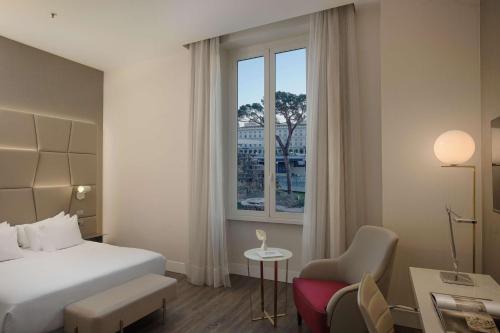 a hotel room with a bed and a window at NH Collection Palazzo Cinquecento in Rome