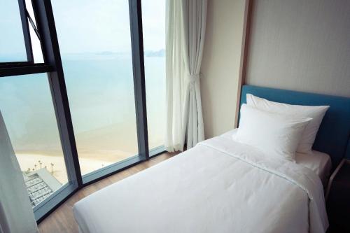 une chambre avec un lit et une grande fenêtre dans l'établissement Alacater hạ long bay, à Hạ Long