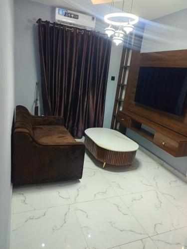 a living room with a couch and a tv at Elnido by Kdove in Ikeja