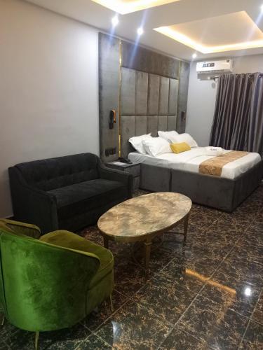 a hotel room with a bed and a couch and a table at Elnido by Kdove in Ikeja