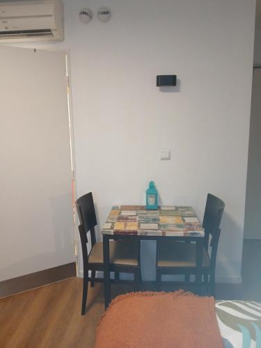 a dining room with a table and four chairs at Escapade entre Ville et Rivière in Nogent-sur-Marne