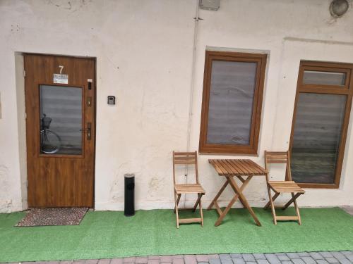 two chairs and a table in front of a building at Apartament Alibi in Przemyśl