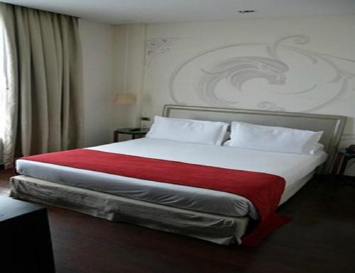 a bedroom with a large bed with a red blanket at Hotel Noble Haven Unit OF Lacasa Near Airport in New Delhi