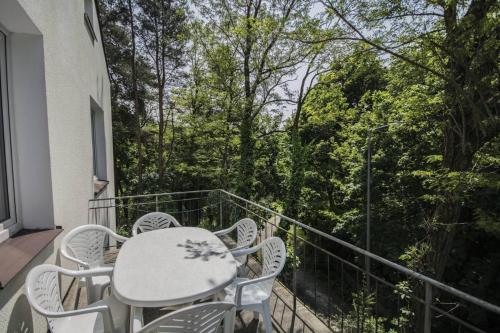 a table and chairs on a balcony with trees at Dom Wczasowy Lech in Susiec