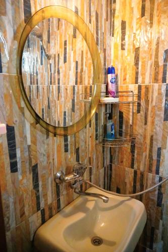 a bathroom with a mirror and a sink at Pospolita Guest House in Kutaisi