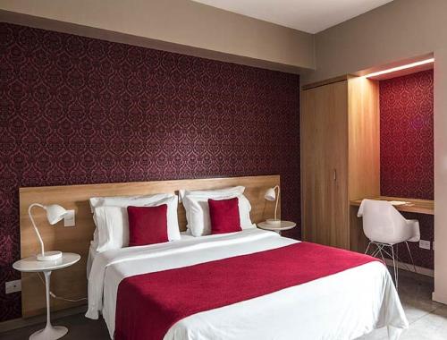 a bedroom with a large bed with a red wall at Hotel Noble Haven Unit OF Lacasa Near Airport in New Delhi