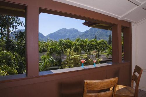 two glasses of wine sitting on a table in front of a window at Hale Ylang Ylang TVNC-5108* in Hanalei