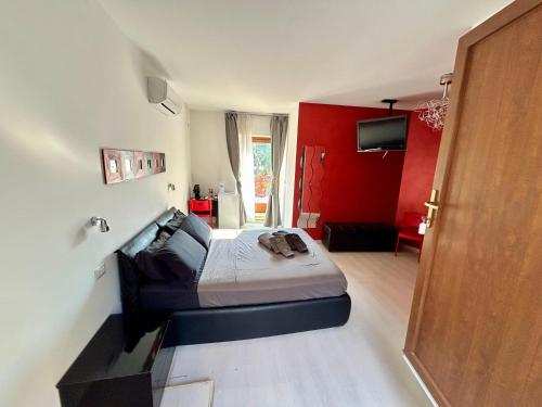 a bedroom with a bed and a red wall at Ninfa Del Lago Bedrooms by Dinamica Real Estate in Posta Fibreno