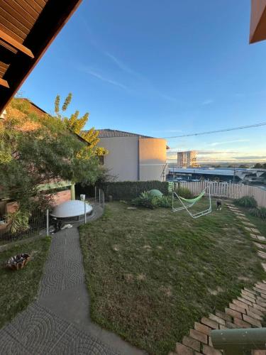 a backyard with a lawn with a swing at Espia Mata - Pousada Hostel in Ponta Grossa