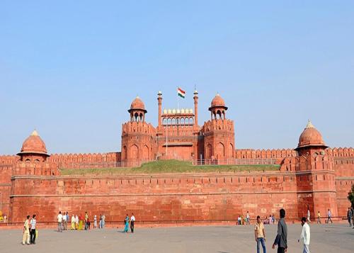 a large red brick building with people walking around it at Hotel Noble Haven Unit OF Lacasa Near Airport in New Delhi