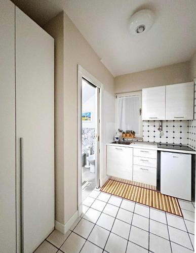 a kitchen with white cabinets and a tile floor at La Dimoraga in Chiubbica