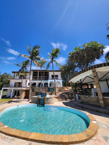 a large swimming pool in front of a house at Rozzies Beach Villa Malindi in Malindi