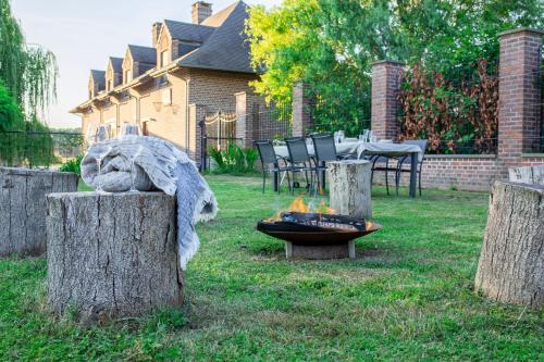 a backyard with a fire pit and chairs and a house at Les jardins du Quesnoy - 25min de Pairi Daiza in Blicquy