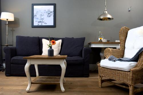 a living room with a blue couch and a table at Das Windhuk in Westerland (Sylt)