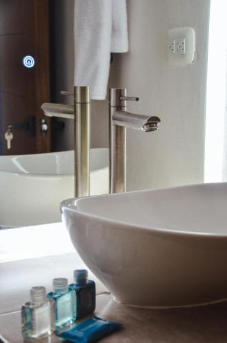 a bathroom with a white sink and a mirror at Astra Beach Club & Resort in Marcelino