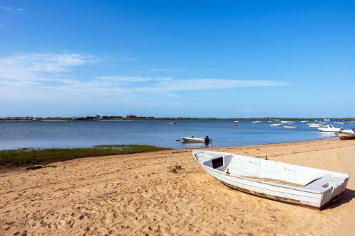a white boat sitting on the sand on a beach at Villa Mar Rompido in El Rompido