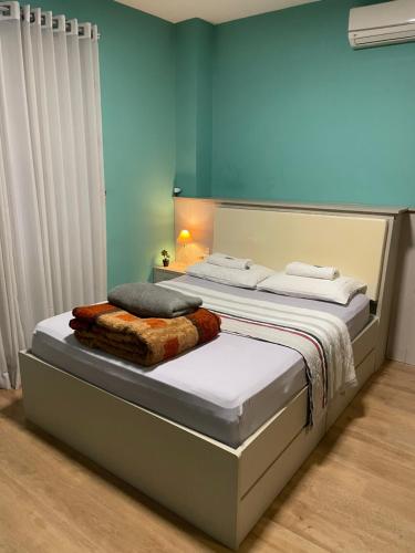 a bedroom with a large bed with white sheets at Apto no centro da cidade mais alemã do Brasil in Pomerode