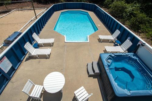 an overhead view of a swimming pool with chairs and a swimming pool at Salty Breeze - Walk to Beach - Pool - Hot Tub - EV in Duck