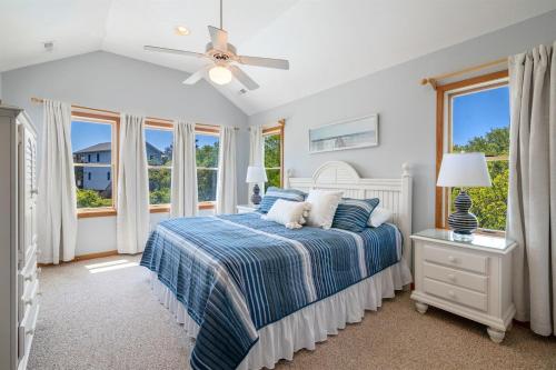 a bedroom with a bed and a ceiling fan at Salty Breeze - Walk to Beach - Pool - Hot Tub - EV in Duck