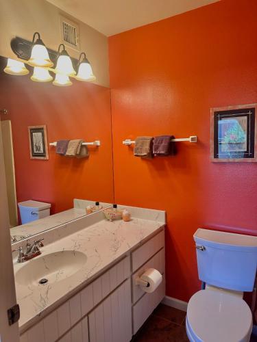 a bathroom with a sink and a toilet and a mirror at Cozy Cactus Inn in Sedona