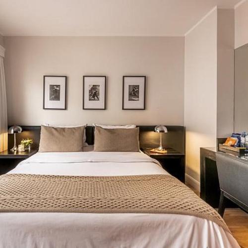 a bedroom with a large bed with three pictures on the wall at Hotel Noble Haven Unit OF Lacasa Near Airport in New Delhi