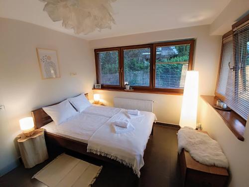 une chambre avec un lit avec deux lampes et deux fenêtres dans l'établissement Mio Apartament Z Ogródkiem Zakopane Kościelisko Free Parking, à Zakopane