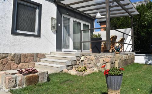 a house with a stone wall and stairs to a door at Corddora Apartman in Mezőkövesd
